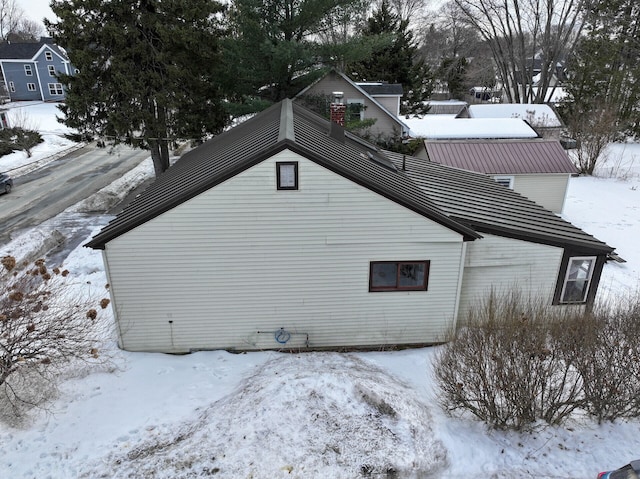 view of snowy exterior featuring metal roof