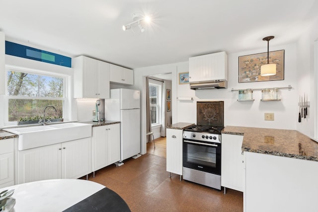 49 Langsford Rd, Kennebunkport, ME 04046 - kitchen featuring stainless steel gas stove, freestanding refrigerator, a sink, dark floors, and white cabinets