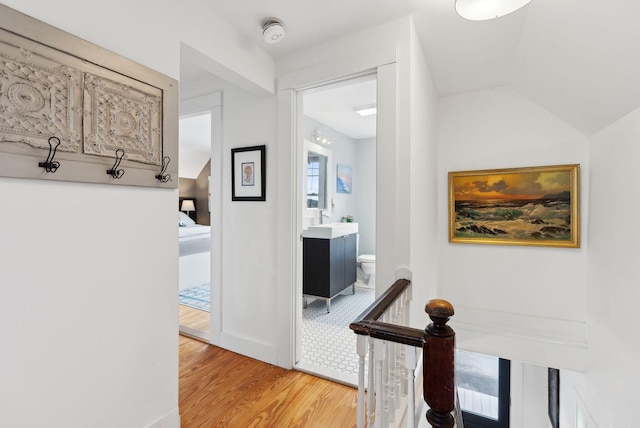 49 Langsford Rd, Kennebunkport, ME 04046 - hallway featuring light wood-type flooring, an upstairs landing, a sink, and vaulted ceiling