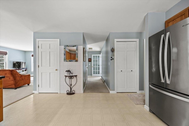 kitchen with baseboards, light floors, and freestanding refrigerator