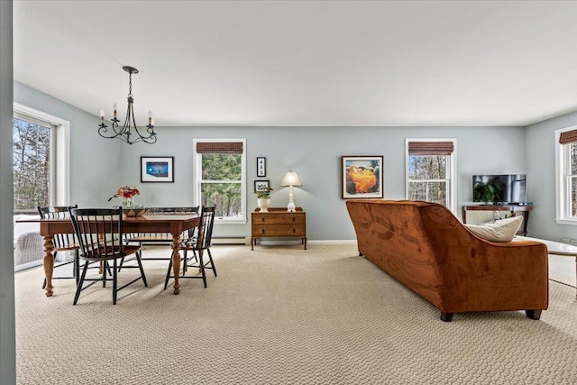 dining room with a baseboard radiator, plenty of natural light, light colored carpet, and a chandelier