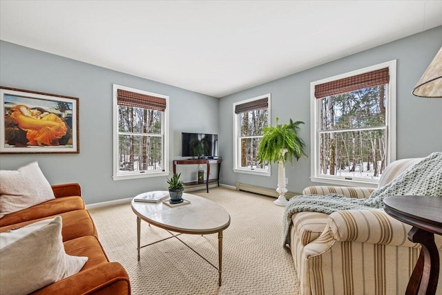 living area with a baseboard heating unit, baseboards, and carpet floors