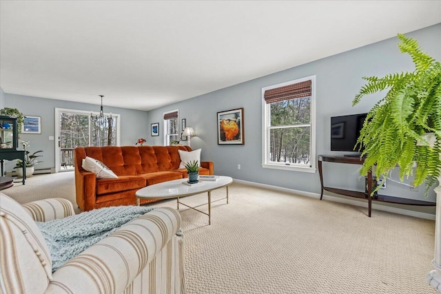 living room with baseboards, carpet floors, and a chandelier