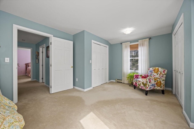 living area featuring light colored carpet, baseboards, and baseboard heating