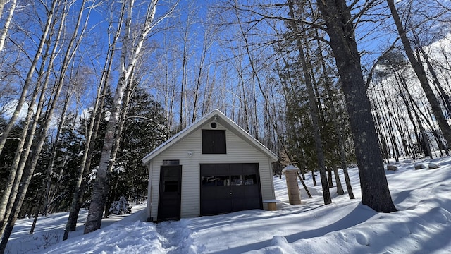 snow covered garage with a detached garage