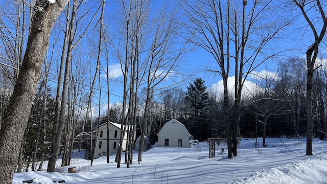 yard layered in snow featuring an outdoor structure and a barn