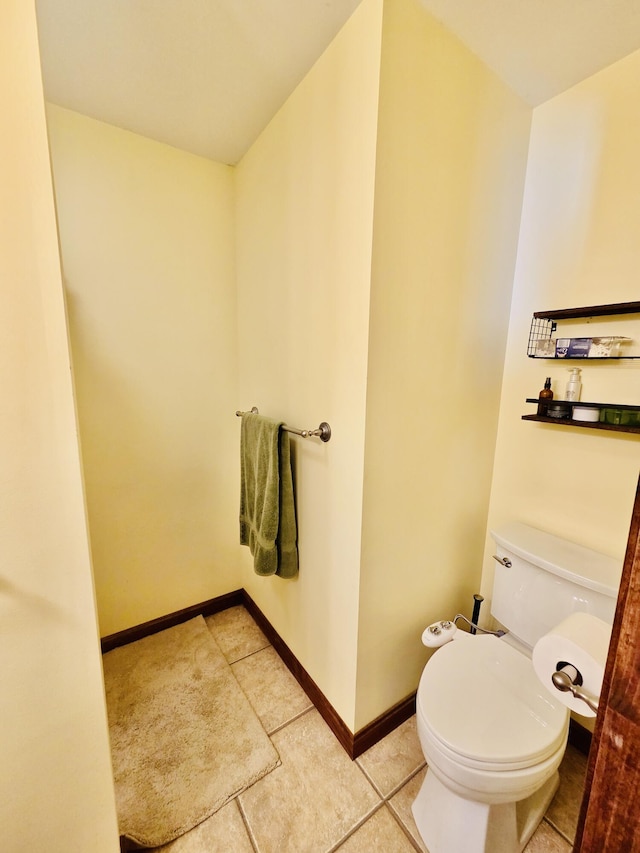 bathroom with tile patterned flooring, toilet, and baseboards