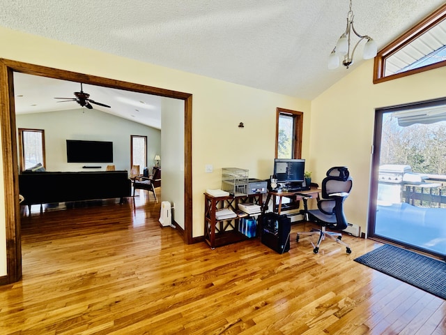 home office featuring vaulted ceiling, a textured ceiling, baseboards, and wood finished floors