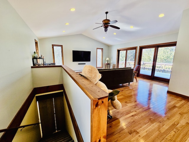 living area featuring lofted ceiling, baseboards, light wood-style flooring, and recessed lighting