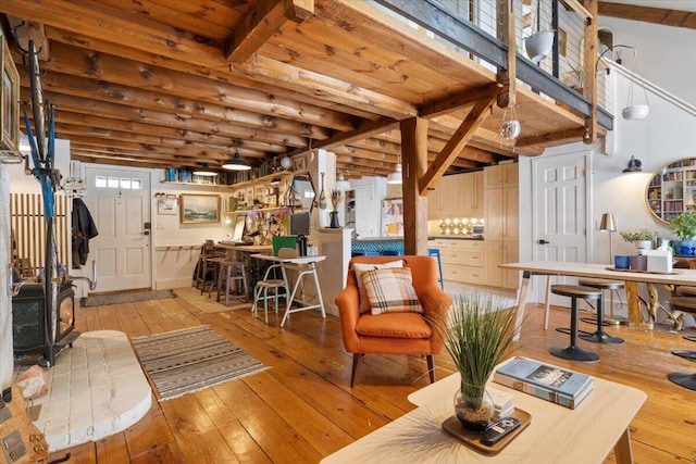 living area featuring beam ceiling, wooden ceiling, and wood-type flooring