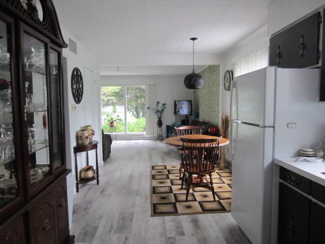 131 Clover St, Madawaska, ME 04756 - kitchen featuring open floor plan, visible vents, light wood-type flooring, and freestanding refrigerator