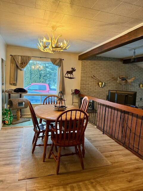 131 Clover St, Madawaska, ME 04756 - dining area with brick wall, beamed ceiling, and wood finished floors