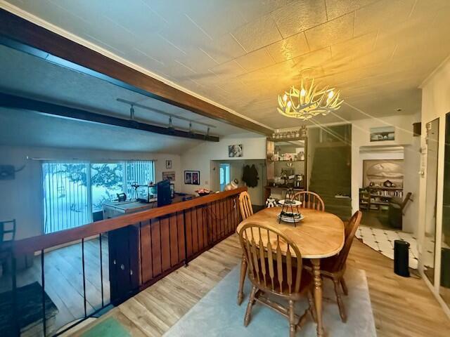 131 Clover St, Madawaska, ME 04756 - dining space featuring an inviting chandelier, wood finished floors, and beamed ceiling