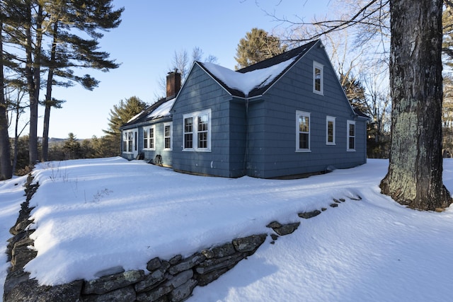 view of snowy exterior with a chimney