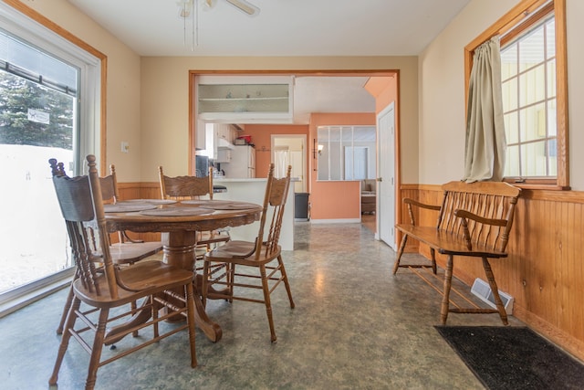 633 Main St, Madawaska, ME 04756 - dining space featuring wooden walls, ceiling fan, and a wainscoted wall