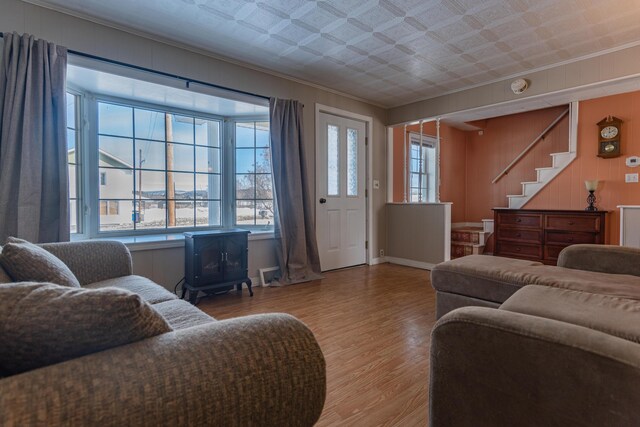 633 Main St, Madawaska, ME 04756 - living area with crown molding, stairs, a wood stove, and wood finished floors
