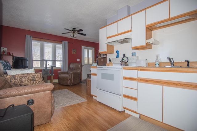 633 Main St, Madawaska, ME 04756 - kitchen with light wood finished floors, open floor plan, under cabinet range hood, light countertops, and white range with electric stovetop