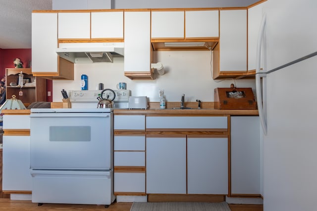 633 Main St, Madawaska, ME 04756 - kitchen with white cabinetry, white appliances, a sink, and under cabinet range hood