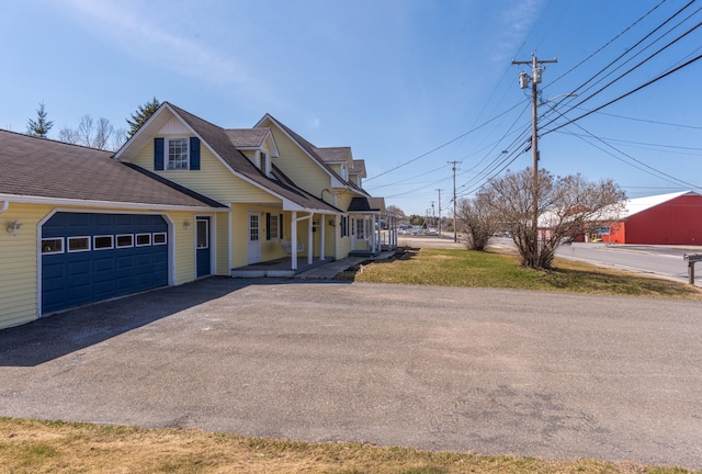 633 Main St, Madawaska, ME 04756 - view of front facade featuring covered porch, a garage, a shingled roof, and driveway