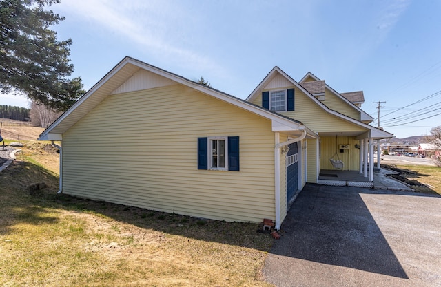 633 Main St, Madawaska, ME 04756 - view of side of home with covered porch, aphalt driveway, and a lawn
