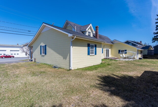 633 Main St, Madawaska, ME 04756 - view of side of home with a shingled roof, a chimney, and a lawn