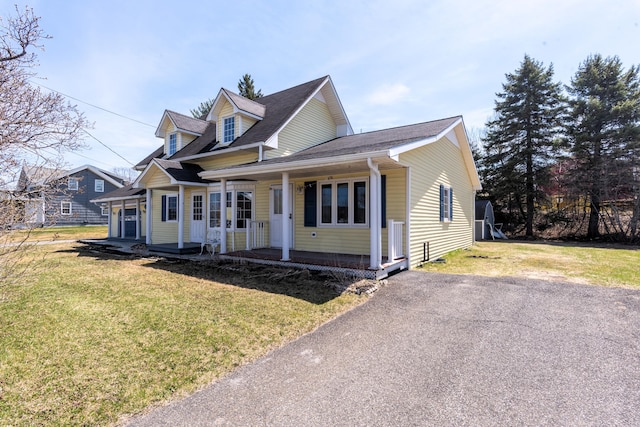 633 Main St, Madawaska, ME 04756 - cape cod-style house with a porch, aphalt driveway, roof with shingles, and a front lawn