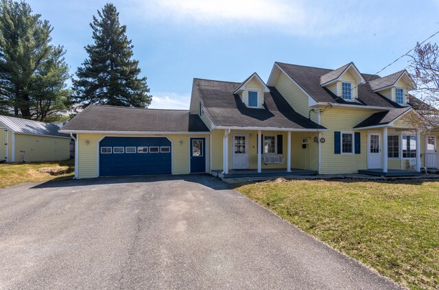 633 Main St, Madawaska, ME 04756 - cape cod house with covered porch, driveway, a garage, and a front yard