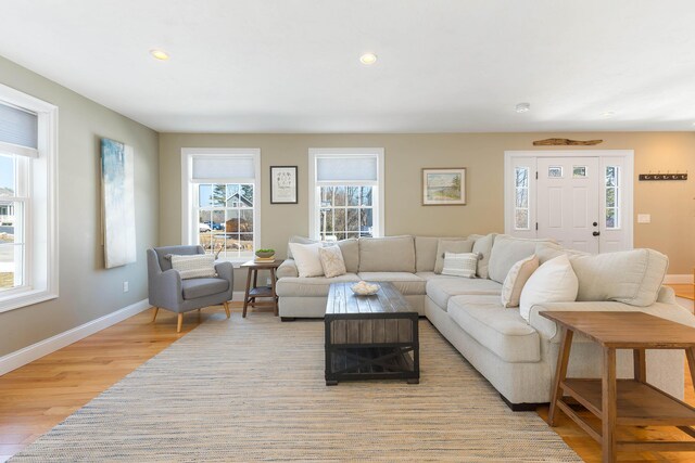 living room with light wood finished floors, recessed lighting, and baseboards