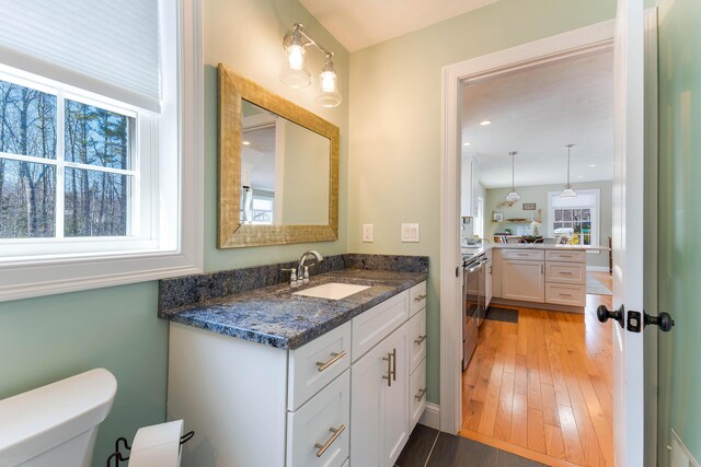 bathroom featuring recessed lighting, toilet, wood finished floors, and vanity