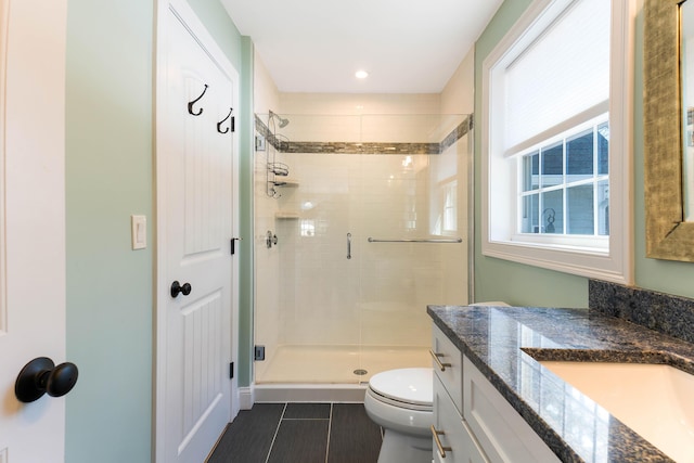 bathroom with toilet, a stall shower, vanity, and tile patterned flooring