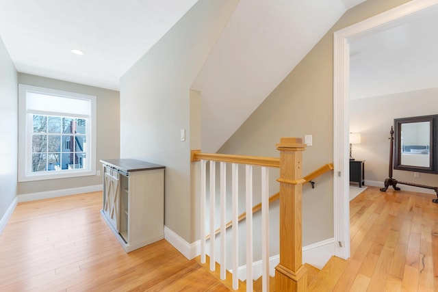 corridor with an upstairs landing, recessed lighting, light wood-style flooring, and baseboards