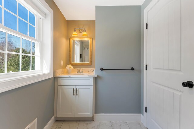 bathroom with baseboards, marble finish floor, and vanity