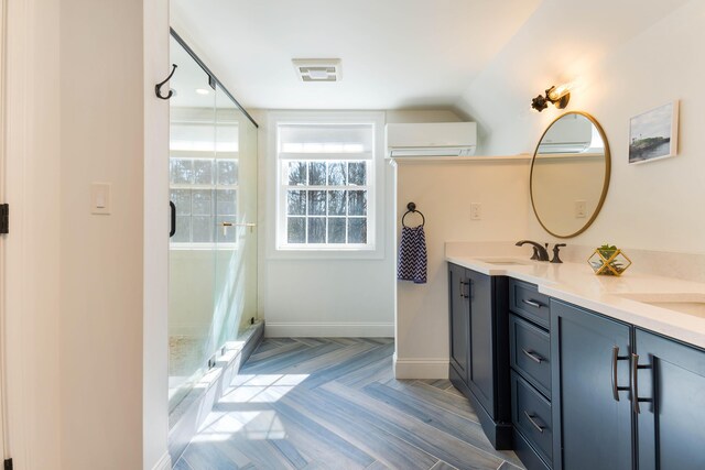 full bath with a stall shower, a sink, double vanity, baseboards, and vaulted ceiling