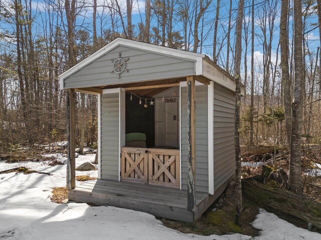 snow covered structure with an outdoor structure and a shed