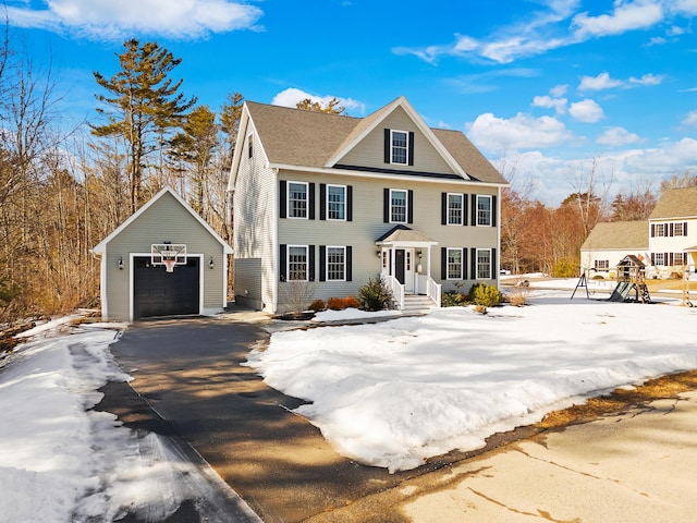 colonial inspired home featuring a garage, driveway, an outdoor structure, and roof with shingles