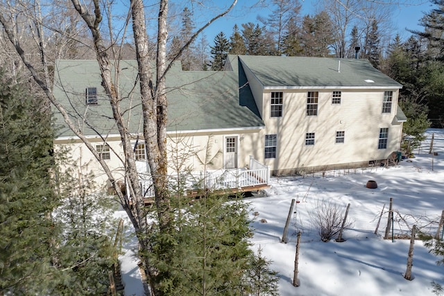 snow covered rear of property featuring a wooden deck