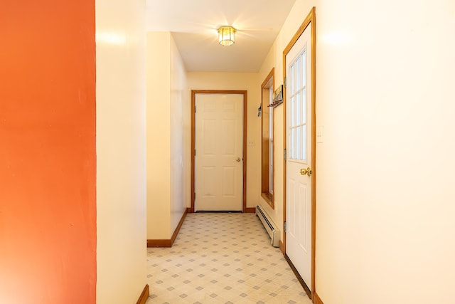 hall featuring light floors, baseboards, and baseboard heating