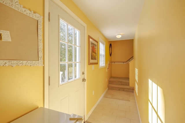 doorway to outside featuring stairway, baseboards, and light tile patterned floors