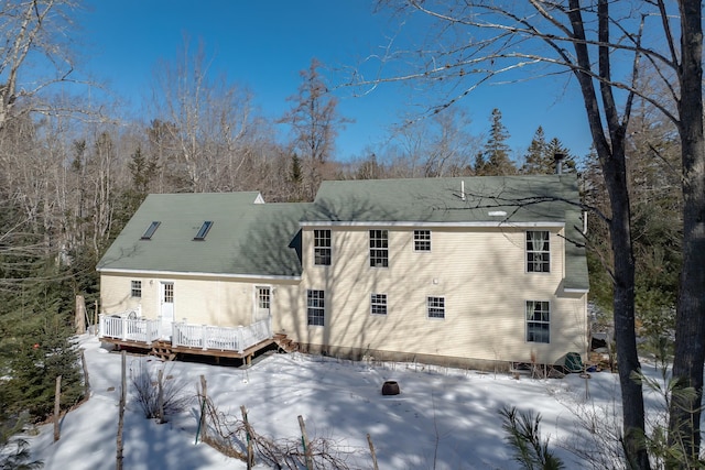 snow covered property featuring a wooden deck