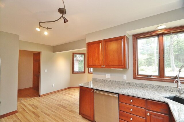220 Church Rd, Bangor, ME 04401 - kitchen featuring dishwasher, light wood-style flooring, brown cabinets, light stone countertops, and a sink