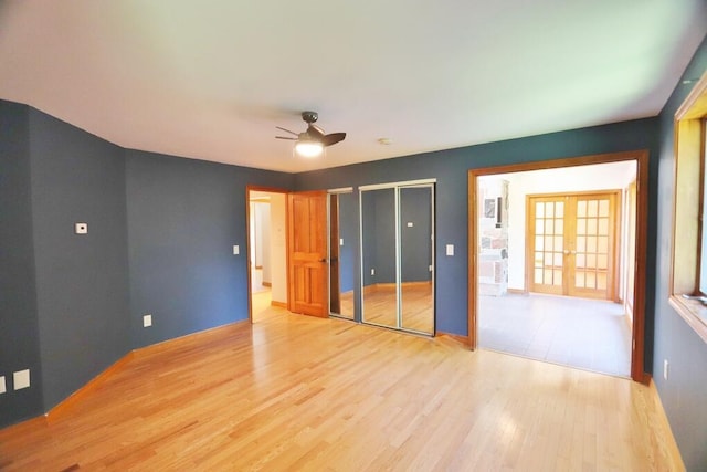 220 Church Rd, Bangor, ME 04401 - unfurnished bedroom with ceiling fan, french doors, light wood-type flooring, and multiple closets