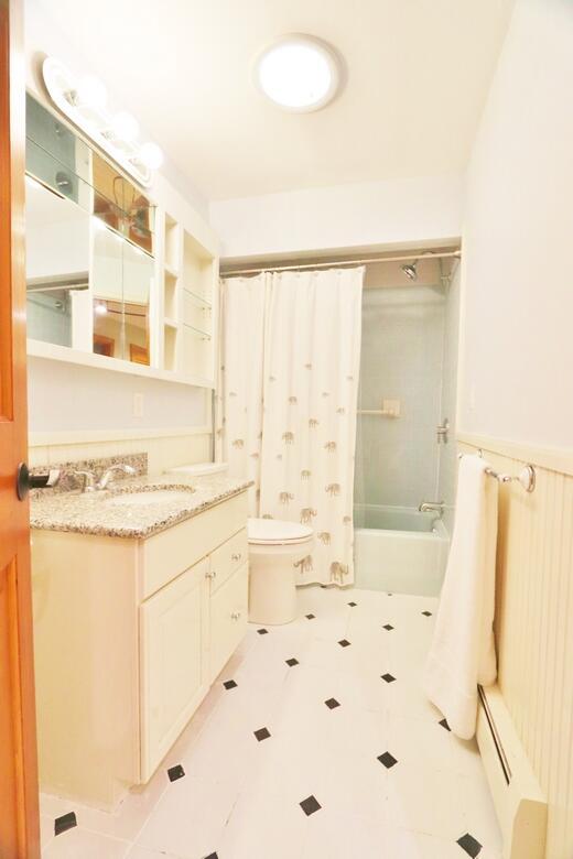 220 Church Rd, Bangor, ME 04401 - bathroom with toilet, shower / bathtub combination with curtain, a baseboard heating unit, and vanity
