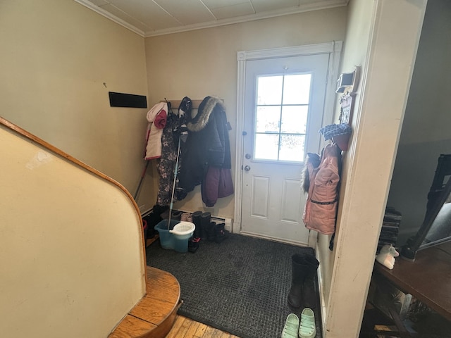 doorway to outside with wood finished floors and crown molding