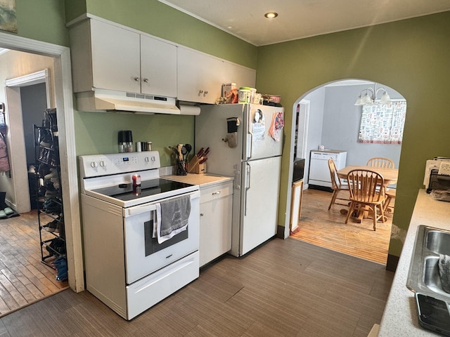 kitchen with arched walkways, light countertops, white cabinets, white appliances, and under cabinet range hood