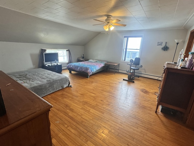 bedroom featuring light wood-style floors, a baseboard radiator, vaulted ceiling, and a ceiling fan