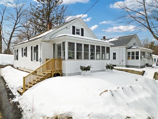 view of front of property with a sunroom and a chimney