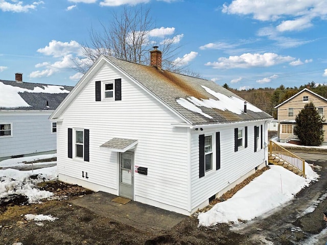 rear view of house with a shingled roof and a chimney