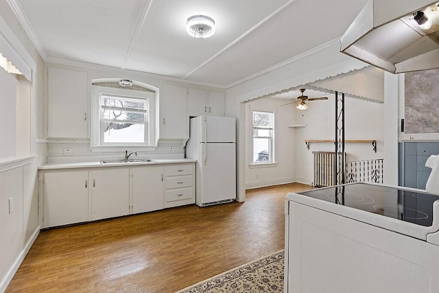 kitchen with freestanding refrigerator, a healthy amount of sunlight, a sink, and range with electric stovetop