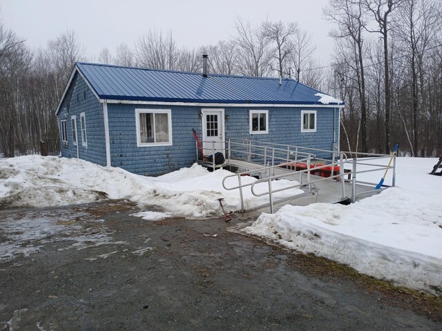 snow covered house with metal roof