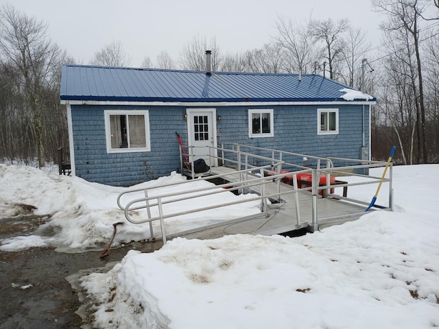 snow covered property featuring metal roof